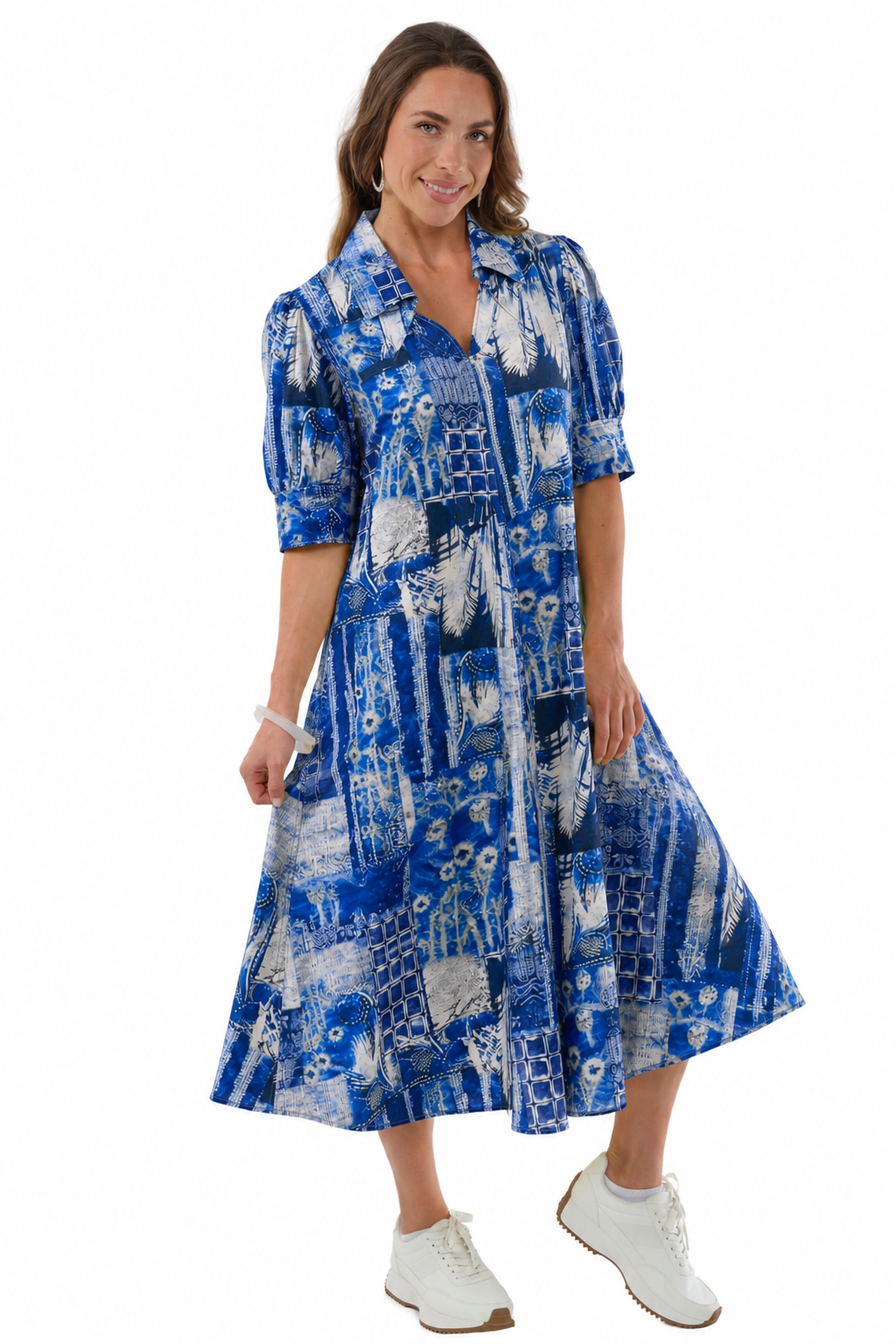 Woman wearing LIOR Amber blue lagoon print puff sleeve midi dress with pointed collar and white sneakers